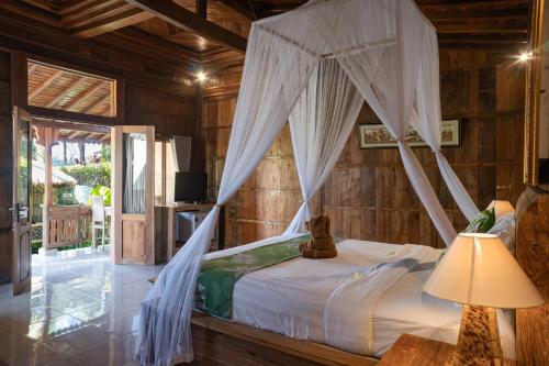 a bedroom with a bed with a canopy at Lawani Resort in Tegalalang