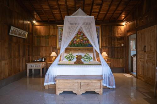 a bedroom with a bed with a canopy at Lawani Resort in Tegalalang