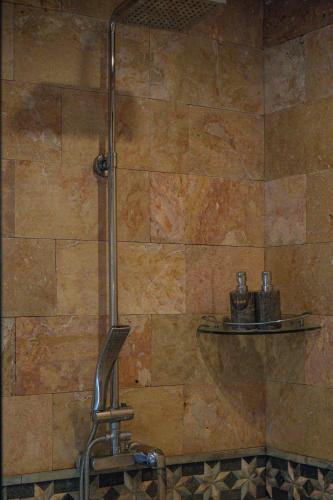 a shower in a bathroom with two shelves on the wall at Lawani Resort in Tegalalang