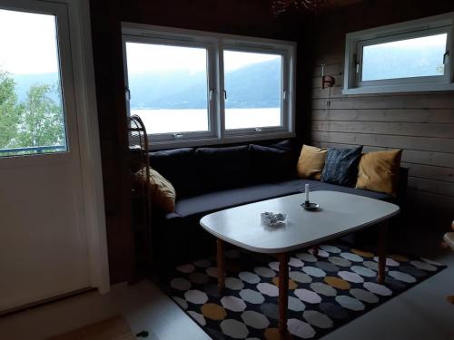 a living room with a couch and a table at Cabin "Pear" in beautiful Hardanger in Indre Alsåker