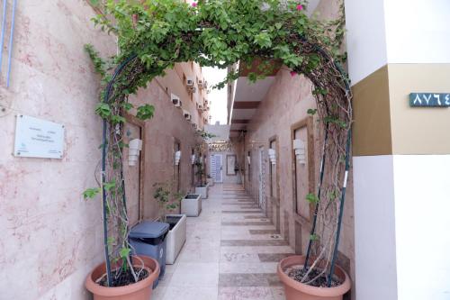 an alley with potted plants on the side of a building at شقق حديقة الروابي إين in Jeddah