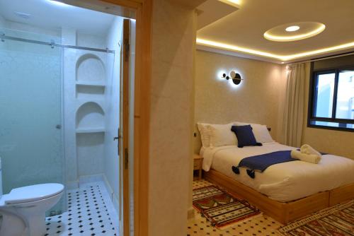 a bedroom with a bed and a shower and a toilet at Tirazir House 3 in Mirleft