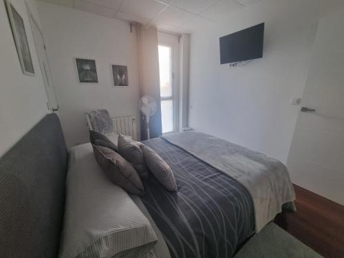 a bedroom with a bed with pillows and a television at Vivienda ideal para familias en San Sebastián in Donostia-San Sebastián