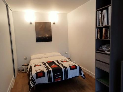 - une petite chambre avec un lit et une étagère dans l'établissement Appartement 11e, à Paris