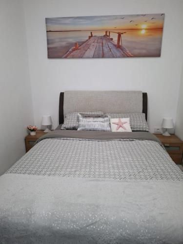 a bedroom with a bed with a painting on the wall at RA Studio Băile Olănești in Livadia