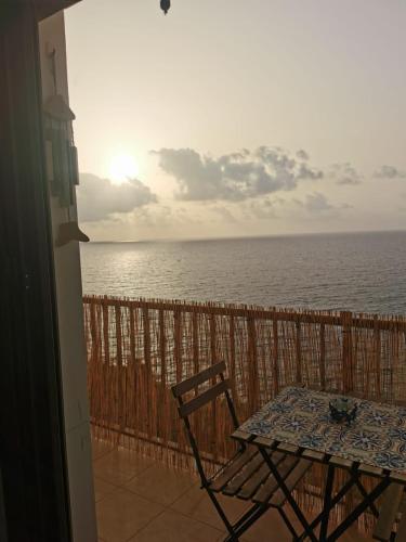 a table and chair on a balcony with the ocean at VistaMare Piedigrotta Casa sul mare in Pizzo