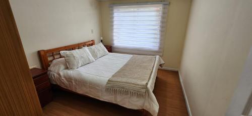 a bedroom with a large bed with a window at Alta Vista de Cahuil in Pichilemu