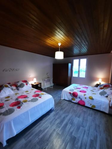 - une chambre avec 2 lits fleuris dans l'établissement La Champenoise, à Arconville