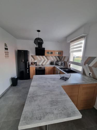 a kitchen with a large counter top in a room at Le chou marin, charmante maison de plain-pied proche d'Audresselles & du Cap gris nez in Audinghen