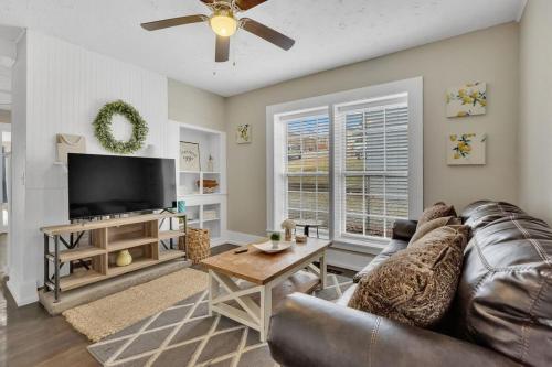 a living room with a couch and a flat screen tv at Lenoir City Cottage - Remodeled - Close to Lake in Lenoir City