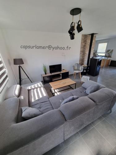 un salon avec un canapé et une table dans l'établissement Le chou marin, charmante maison de plain-pied proche d'Audresselles & du Cap gris nez, à Audinghen