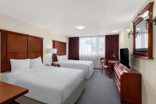 une chambre d'hôtel avec deux lits et une télévision dans l'établissement Howard Johnson by Wyndham Toluca, à Toluca