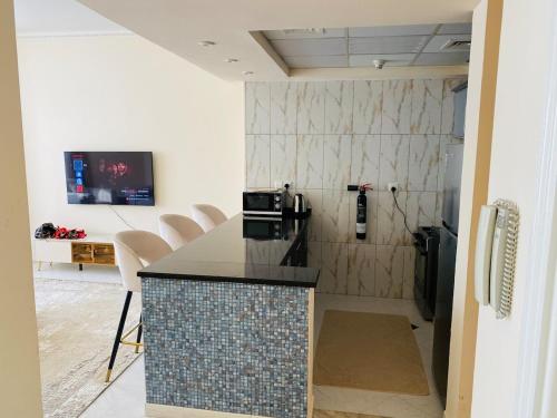 cocina con encimera y sillas en una habitación en Apartment in Sharjah Luxury Apartment in majaz, en Sharjah