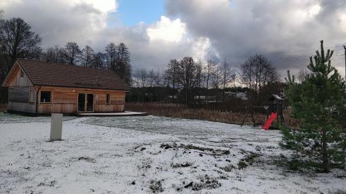 a small wooden house with snow on the ground at Vergi puhkemajad in Vergi