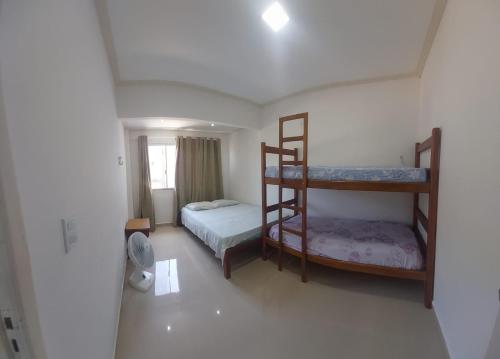 a bedroom with two bunk beds and a fan at Seu Segundo Lar in Valença