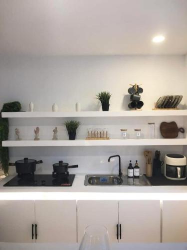 a white kitchen with a stove and white shelves at NEW Exclusive Luxury Pool Villa in Mactan Island