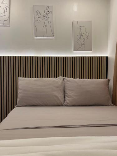 a bed in a bedroom with two pictures on the wall at NEW Exclusive Luxury Pool Villa in Mactan Island