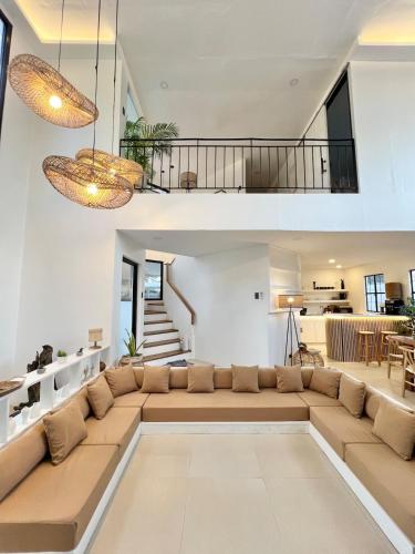 a living room with a large couch and a staircase at NEW Exclusive Luxury Pool Villa in Mactan Island
