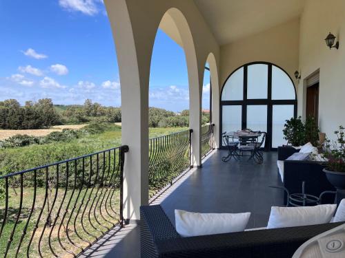a patio with a table and chairs on a balcony at Les Lauriers, chambre d'hôtes in Siamanna