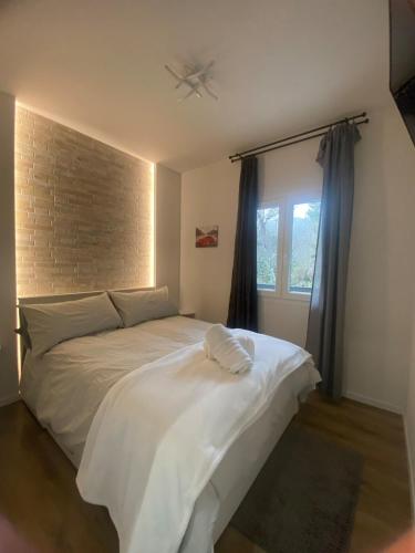 a bedroom with a white bed with a ceiling fan at Elegant Tuscany Mountain Villa in Momigno