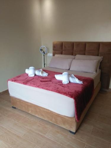 a bed with a red blanket and white towels on it at Lake House Boulaouane in El Jadida
