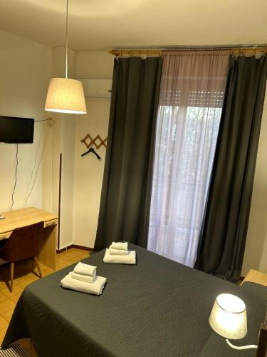 a bedroom with a bed with two towels on it at Amica in Salsomaggiore Terme