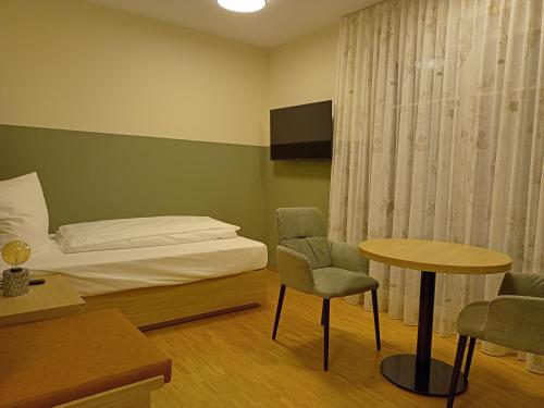 a bedroom with a bed and a table and chairs at Altes Bräuhaus, Ferienwohnungen und Apartments in Gaildorf in Gaildorf