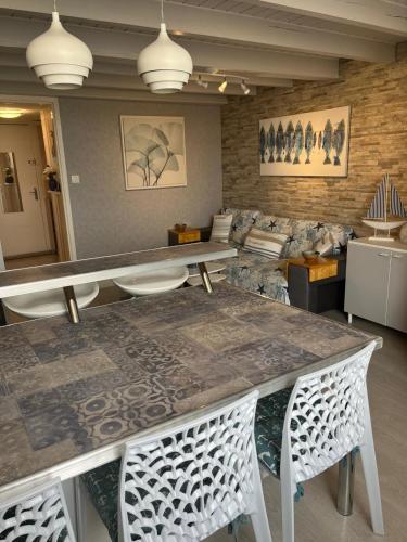 un salon avec une table, des chaises et un canapé dans l'établissement Le cocon bleu du cap, au Cap d'Agde