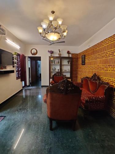 a living room with a couch and a chandelier at Holiday home stay Puducherry in Puducherry