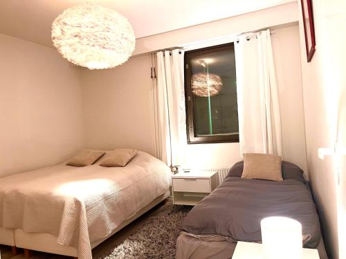 a bedroom with two beds and a window at Lapland Escape - Cozy, equipped and free parking in Rovaniemi