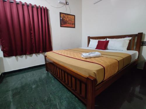 a bed in a room with red curtains and a bed sidx sidx sidx at Holiday home stay Puducherry in Puducherry