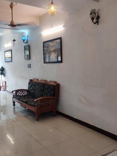 a living room with a couch against a white wall at Holiday home stay Puducherry in Puducherry