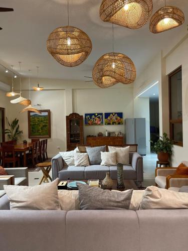 a living room with couches and chandeliers at Elyu Guesthouse in Bauang