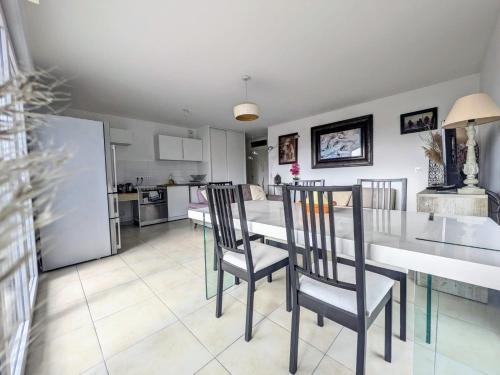 une cuisine et une salle à manger avec une table et des chaises dans l'établissement Appartement la Belle vue - Double parking privé, à Fréjus