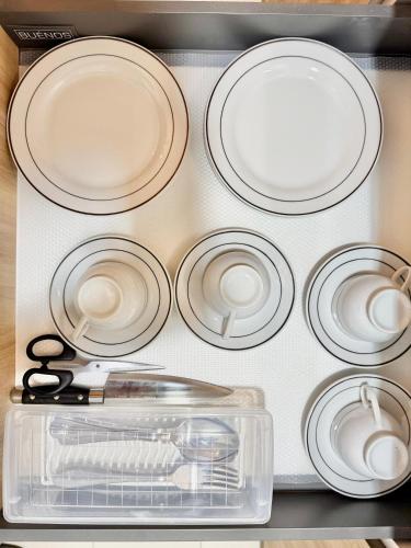 a group of white plates and a pair of scissors at Gamuda Cove,Splash Mania by Solace Place in Pulau Kempas