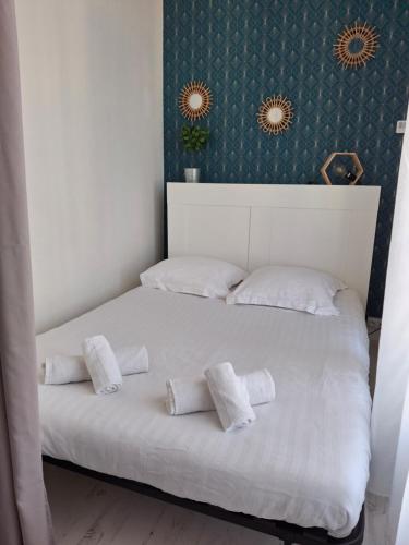 Una cama blanca con tres almohadas encima en Appartement lumineux dans les hauts de Recouvrance, en Brest