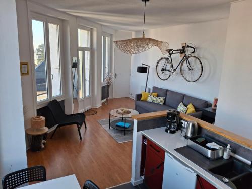 une cuisine et un salon avec un vélo accroché au mur dans l'établissement Appartement lumineux dans les hauts de Recouvrance, à Brest