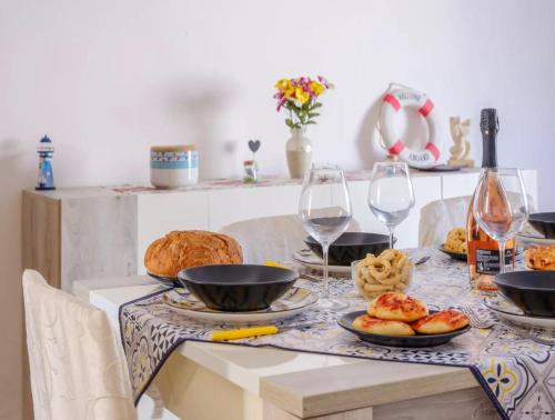 a table topped with plates of food and wine glasses at Villa with Sea Views in Torre Squillace Relax in Style in Torre Squillace