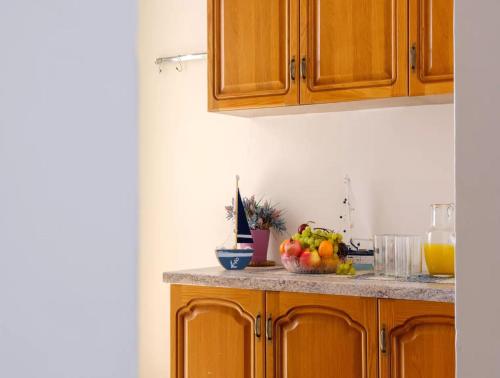 a kitchen with wooden cabinets and a bowl of fruit on a counter at Villa with Sea Views in Torre Squillace Relax in Style in Torre Squillace