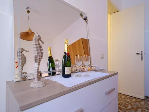 two bottles of wine and glasses on a dresser at Villa with Sea Views in Torre Squillace Relax in Style in Torre Squillace