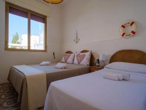 a room with two beds and a window at Villa with Sea Views in Torre Squillace Relax in Style in Torre Squillace