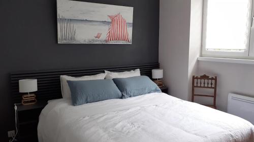 une chambre avec un grand lit blanc avec deux lampes dans l'établissement Un vrai paradis avec terrasse face à la mer, à Plougasnou