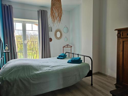 a bedroom with a bed with blue towels on it at Au contact de la nature in Chatuzange-le-Goubet