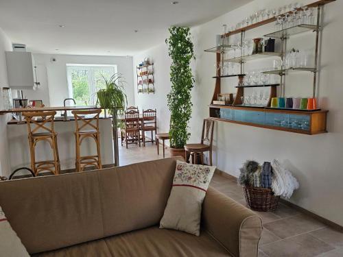 un salon avec un canapé et une cuisine dans l'établissement Au contact de la nature, à Chatuzange-le-Goubet