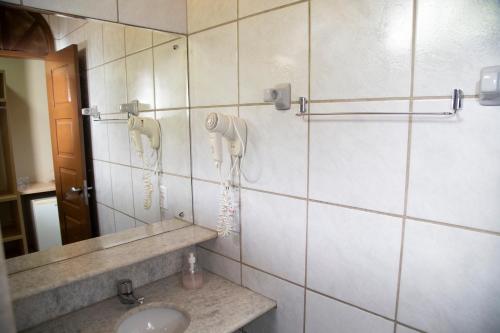 a bathroom with a sink and a phone on the wall at Pousada da Terra in Natal
