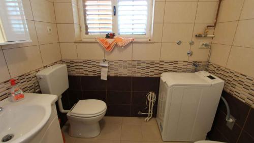 a small bathroom with a toilet and a sink at One-Bedroom Apartment Malinska near Sea 2 in Malinska
