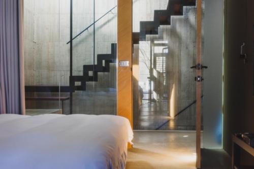 a bedroom with a bed and a staircase at 陸貳Villa 宜蘭包棟民宿 l 寵物友善 l 烤肉 l KTV in Dongshan