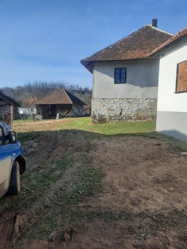 a dirt road in front of a white house at Maruška in Arandjelovac