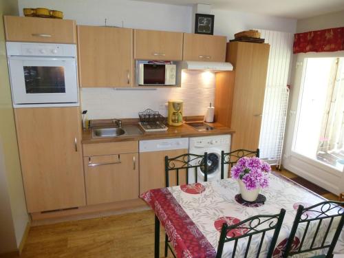 a small kitchen with a table with a vase of flowers on it at G2 Fully equipped apartment 1 à 4 pers 3 stars WiFi in Le Tholy