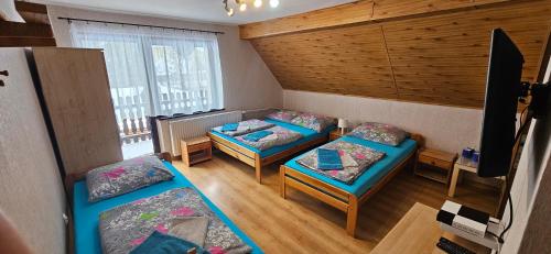a small room with two beds and two chairs at Gazdówka "Pod Pstrągiem" in Korbielów
